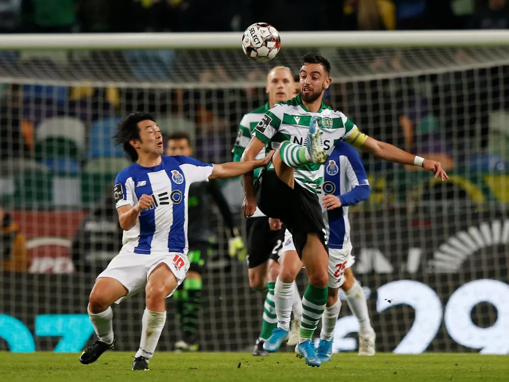 Bruno Fernandes sedang berebut bola dengan pemain FC Porto, Shoya Nakajima. (REUTERS/Rafael Marchante)