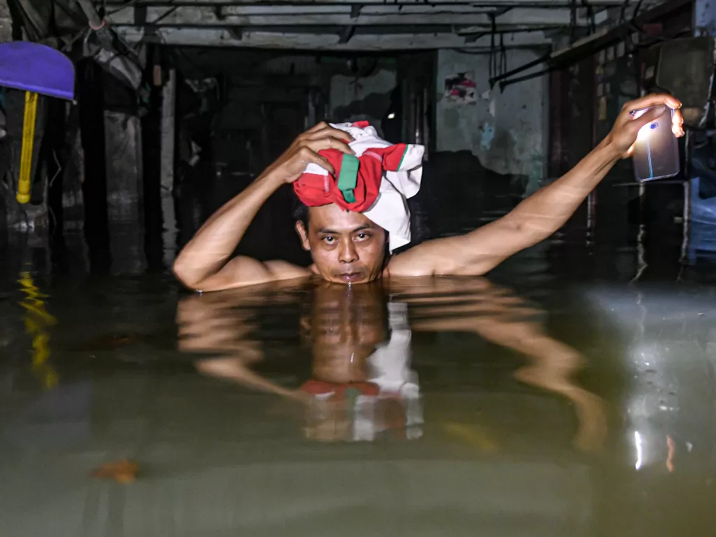 Seorang warga melintasi banjir di kawasan Kampung Baru, Kembangan, Jakarta Barat, Kamis (2/1/2020).(ANTARA FOTO/Muhammad Adimaja/foc).