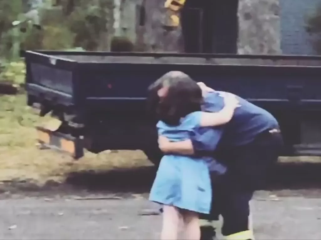 Seorang ayah yang menjadi pemadam kebakaran memeluk kedua anaknya. (photo/Instagram/@mrsbrookemunro)