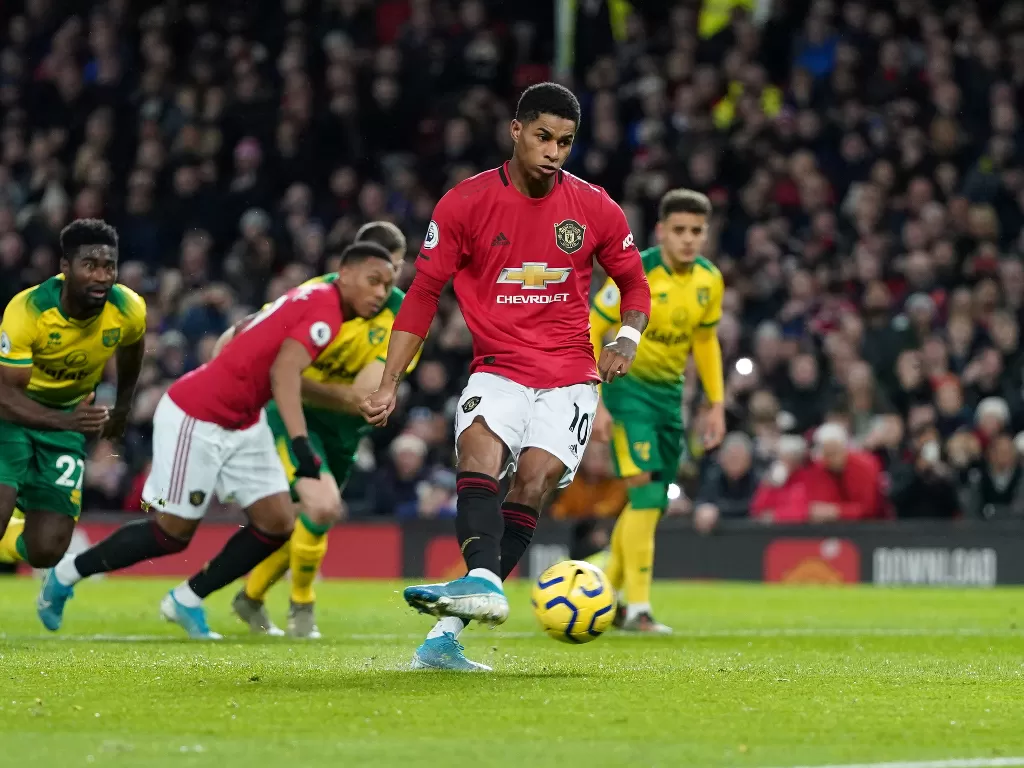 Marcus Rashford menendang bola dari kotak penalti ke gawang Norwich City.(REUTERS/Jon Super)