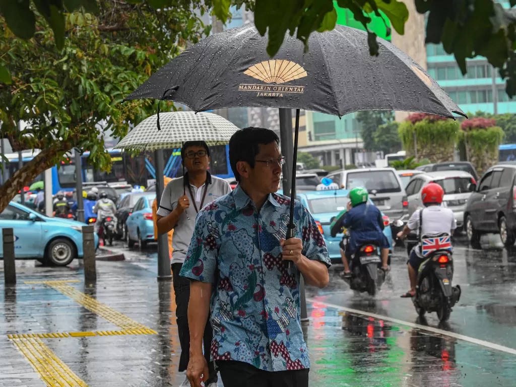 Warga berjalan menggunakan payung saat turun hujan di Jakarta, Jumat (10/1/2020).(ANTARA FOTO/Muhammad Adimaja/wsj).
