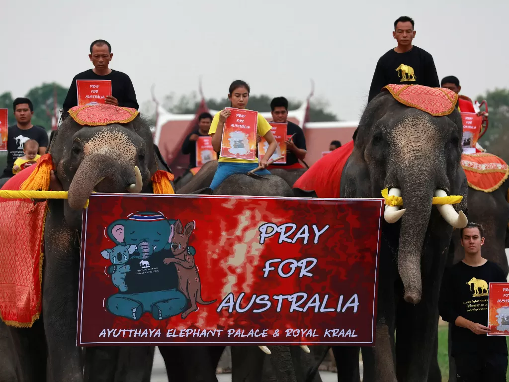 Para siswa dan sekelompok gajah berdoa untuk kebakaran hutan Australia, di Ayutthaya, Thailand. (photo/REUTERS/Soe Zeya Tun)