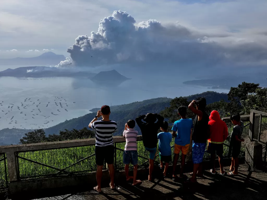 Warga melihat Gunung Berapi Taal yang meletus di Kota Tagaytay. (photo/REUTERS/Eloisa Lopez)