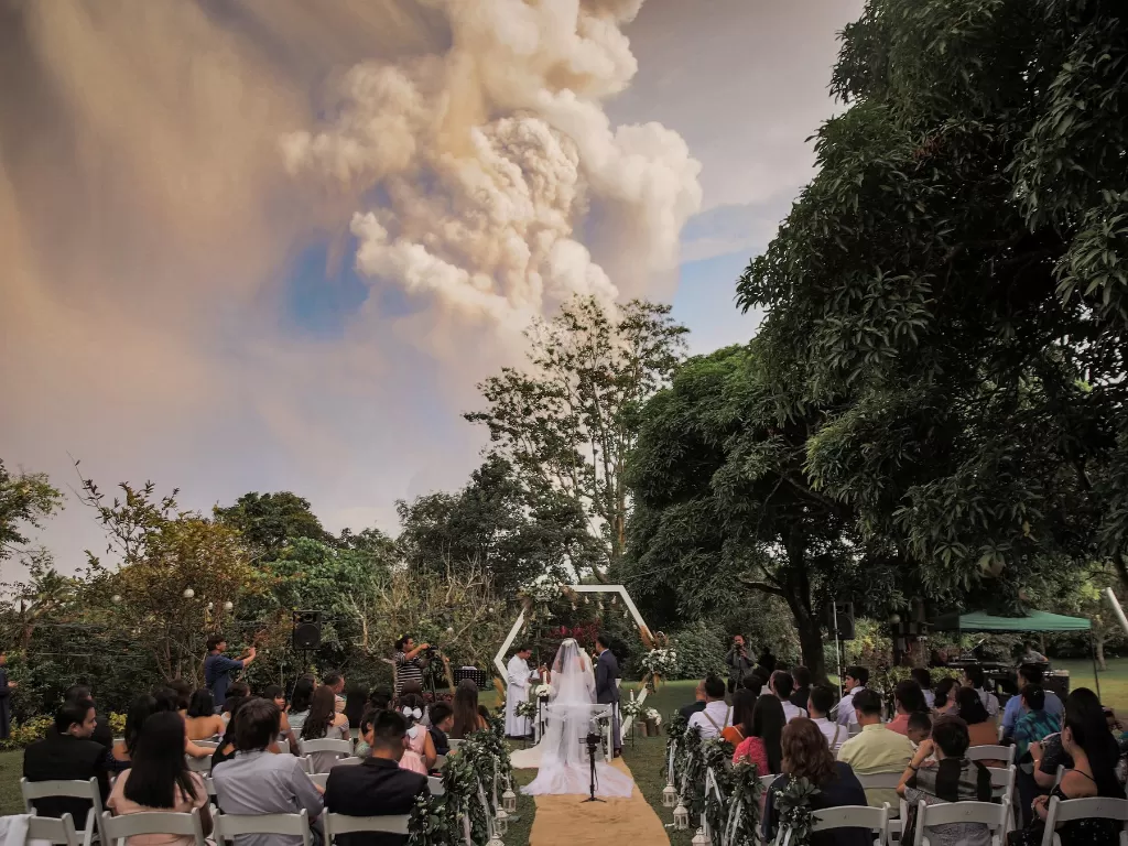  Suasana upacara pernikahan dengan latar belakang letusan Gunung Api Taal di Alfonso, Cavite, Filipina, Minggu (12/1/2020). (REUTERS/Social Media/Randolf Evan Photography)