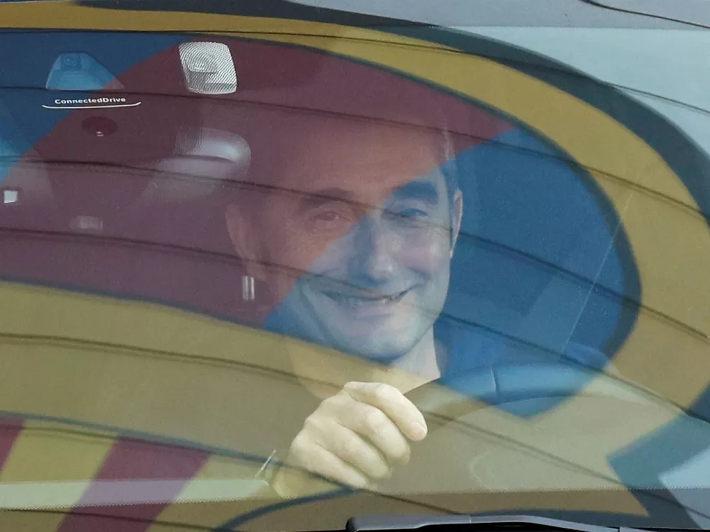 Pelatih FC Barcelona Ernesto Valverde meninggalkan pusat pelatihan Joan Gamper, dan terlihat lambang tim Barcelona yang terefleksi di kaca mobilnya, di Barcelona, Spanyol, Senin (13/1/2020). (REUTERS/Albert Gea)