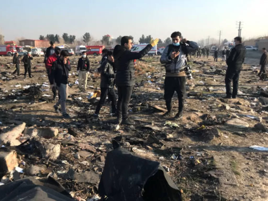 Tim penyelamat memeriksa puing-puing pesawat Boeing 737-800 milik Ukraine International Airlines yang jatuh setelah lepas landas dari bandara Imam Khomeini di Teheran pada 8 Januari 2020. (REUTERS/WANA/Nazanin Tabatabaee)