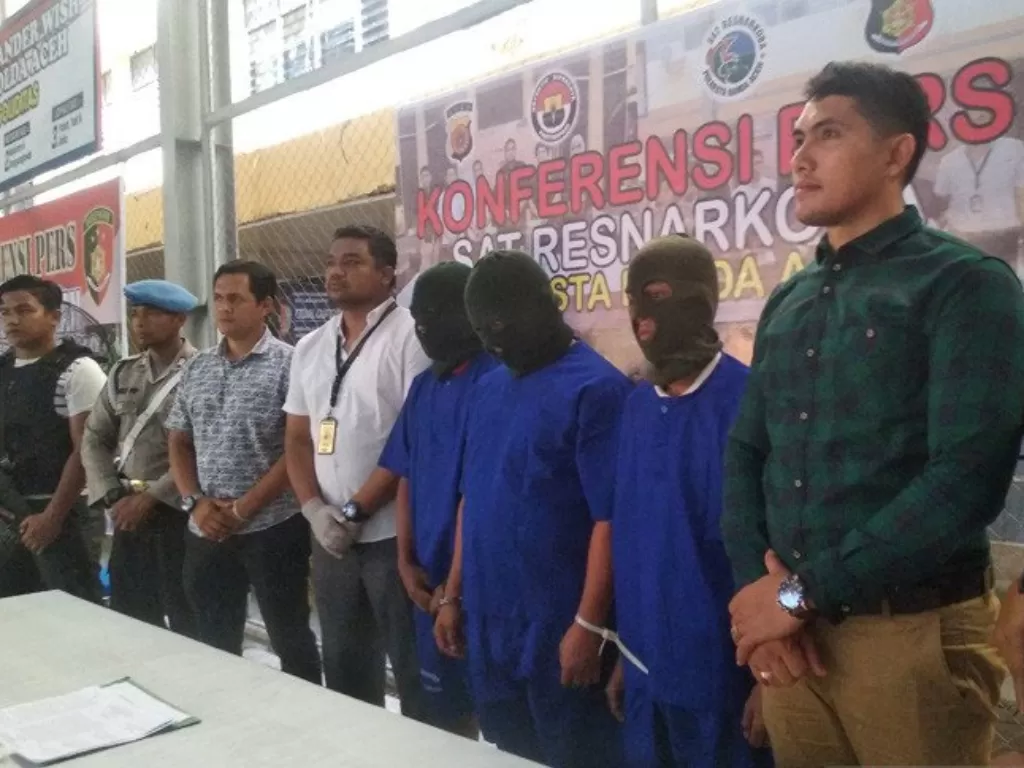 Polisi mengapit tiga tersangka narkoba yang hendak menjual sabu-sabu kepada polisi yang menyamar di Mapolresta Banda Aceh, Kamis (16/1/2020). photo/Antara/M Haris SA