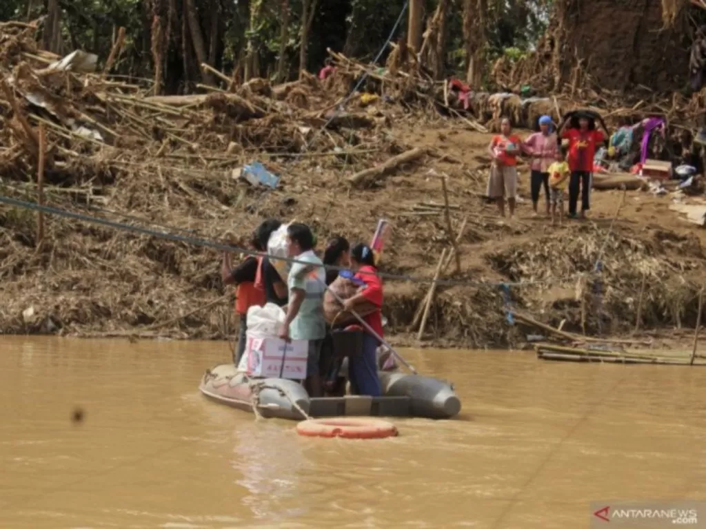 Sejumlah warga menyeberangi Sungai Ciberang dengan perahu karet di Kampung Susukan, Sajira, Lebak, Banten, Senin (13/1/2020), karena jembatan penyeberangan jembatan putus diterjang banjir bandang pada Rabu (1/1). (ANTARA FOTO/Weli Ayu Rejeki)