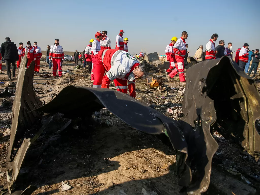 Pekerja bulan sabit memeriksa puing-puing dari pesawat Ukraine International Airlines, yang jatuh setelah lepas landas dari bandara Iran Imam Khomeini, di pinggiran Teheran, Iran 8 Januari 2020 (Wana News Agency/Nazanin Tabatabaee)