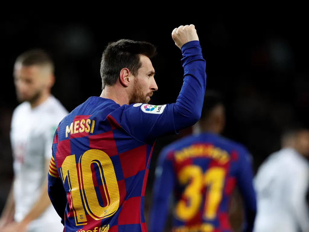 Lionel Messi melakukan selebrasi setelah mencetak gol ke gawang Granada. (REUTERS/Albert Gea)