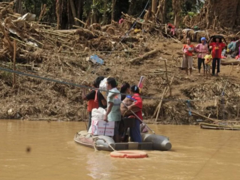 Sejumlah warga menyeberangi Sungai Ciberang dengan perahu karet di Kampung Susukan, Sajira, Lebak, Banten, Senin (13/1/2020), karena jembatan penyeberangan jembatan putus diterjang banjir bandang pada Rabu (1/1). (ANTARA FOTO/WELI AYU REJEKI)