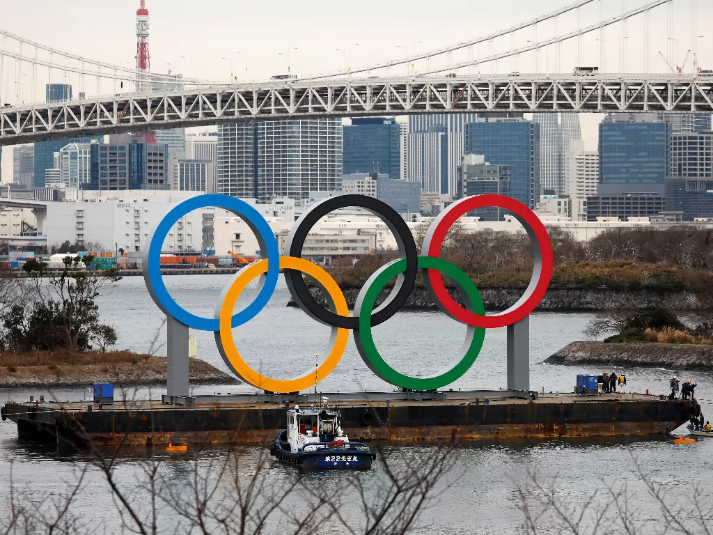 Cincin Olimpiade raksasa dipasang di area tepi laut, dengan Rainbow Bridge (Jembatan Pelangi) sebagai latar belakang, menjelang upacara peresmian Olimpiade Musim Panas Tokyo 2020 di Odaiba Marine Park, Tokyo, Jepang, Jumat (17/1). photo/REUTERS/Issei Kato