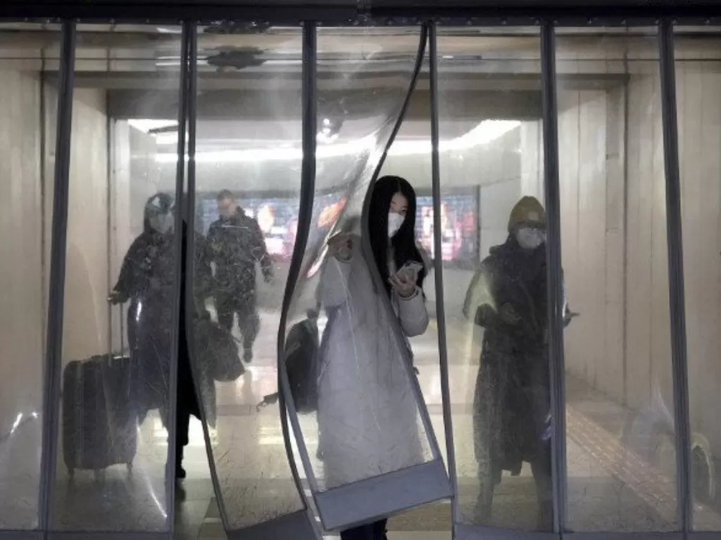 Sejumlah warga Tiongkok memakai masker saat berjalan menuju stasiun bawah tanah kereta subway di Beijing, Tiongkok, Selasa (21/1/2020). photo/REUTERS/Jason Lee