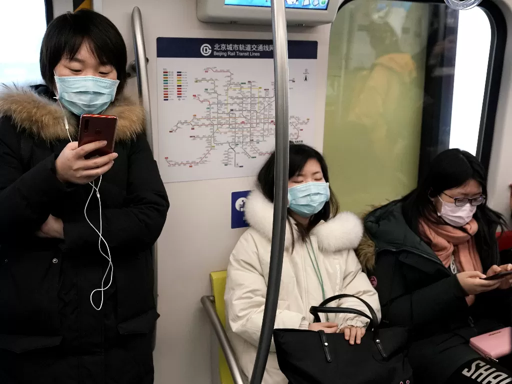 Orang-orang yang memakai masker di kereta bawah tanah di Beijing. (REUTERS/Jason Lee)