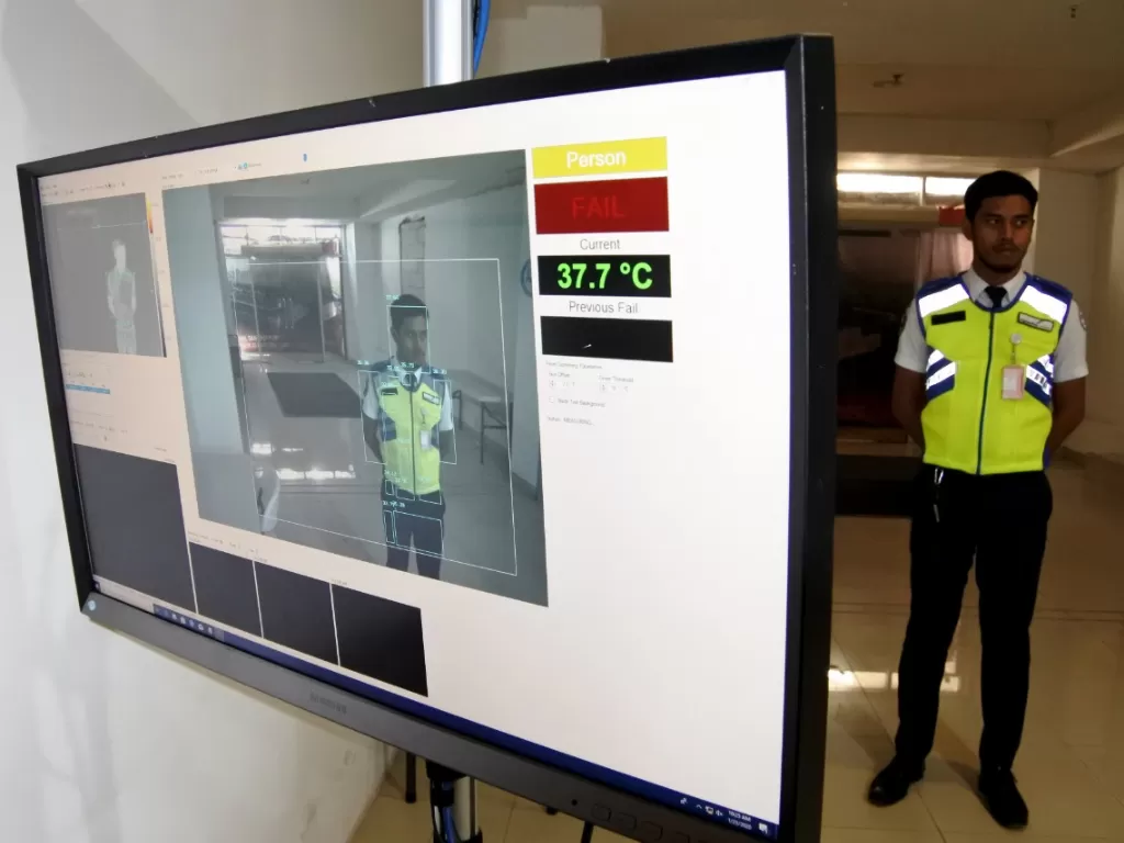 Seorang petugas keamanan berdiri di depan alat pendeteksi suhu tubuh yang dipasang di Terminal Kedatangan Internasional Bandara El Tari, Kupang, NTT, Kamis (23/1/2020). (ANTARA FOTO/Kornelis Kaha)