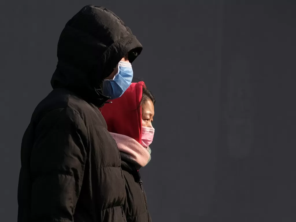 Warga mengenakan masker untuk mencegah penularan virus corona di Beijing, Tiongkok (REUTERS/Carlos Garcia Rawlins).