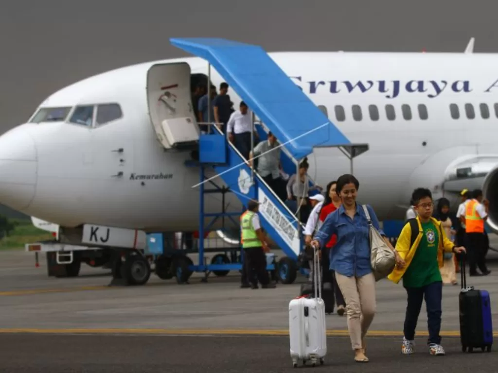 Sejumlah penumpang turun dari pesawat Sriwijaya Air di Bandara Abdul Rahman Saleh, Malang, Jawa Timur. (ANTARA FOTO/Ari Bowo Sucipto)