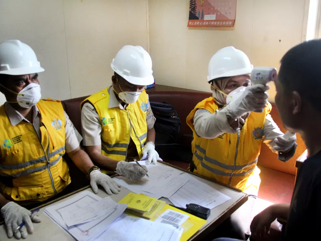 Petugas otoritas kesehatan memeriksa suhu tubuh seorang kru kapal MV Vung Hai berbendera Panama dari Hongkong menggunakan thermometer non kontak di Pelabuhan PT Pelindo I Dumai di Dumai, Riau, Jumat (24/1/2020). (ANTARA FOTO/Aswaddy Hamid)