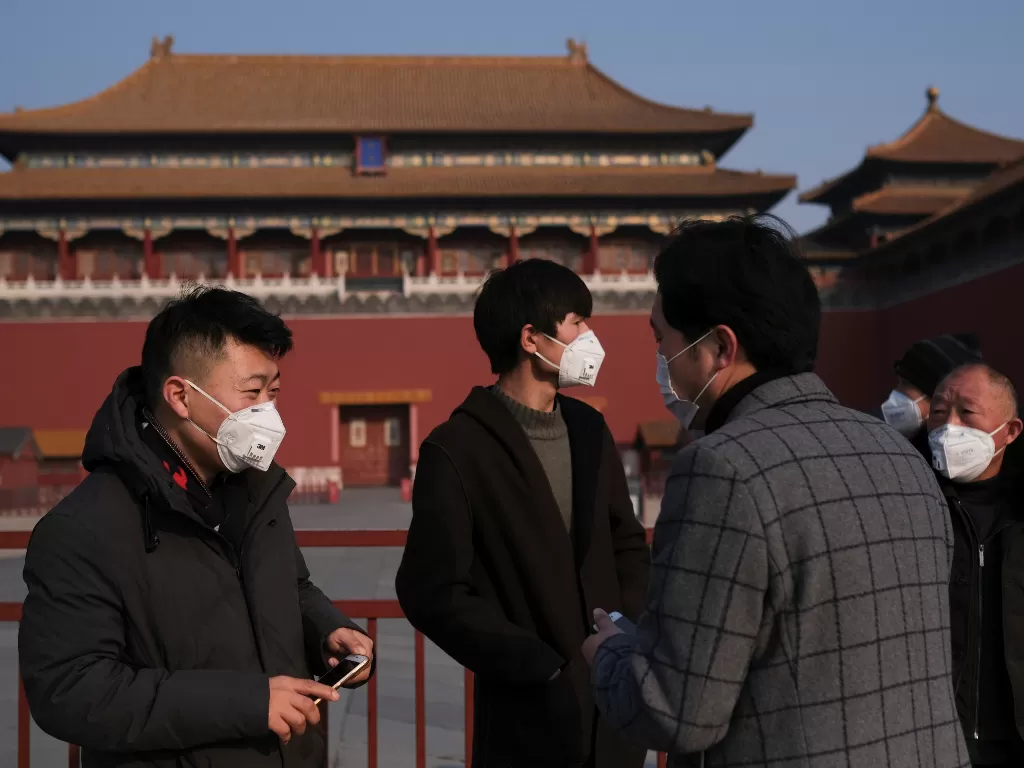 Warga memakai masker di depan Kota Terlarang, Tiongkok (REUTERS/Carlos Garcia Rawlins)