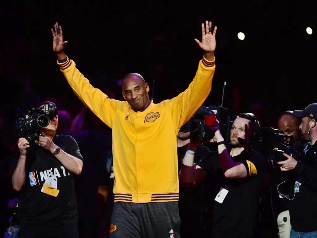 Pemain LA Lakers Kobe Bryant melambai ke penonton saat berjalan di lapangan sebelum pertandingan melawan Utah Jazz di Staples Center, Los Angeles, AS, 13 April 2016. (REUTERS/Robert Hanashiro-AS TODAY Sports)