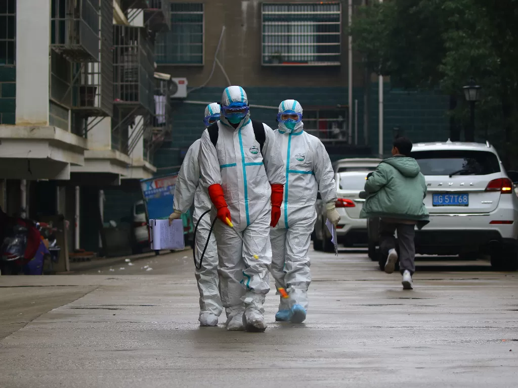 Pekerja dari Departemen Pengendalian dan Pencegahan Penyakit Ruichang, Jiangxi, Tiongkok mendisinfeksi area perumahan setelah adanya virus korona baru. (REUTERS via Cnsphoto)