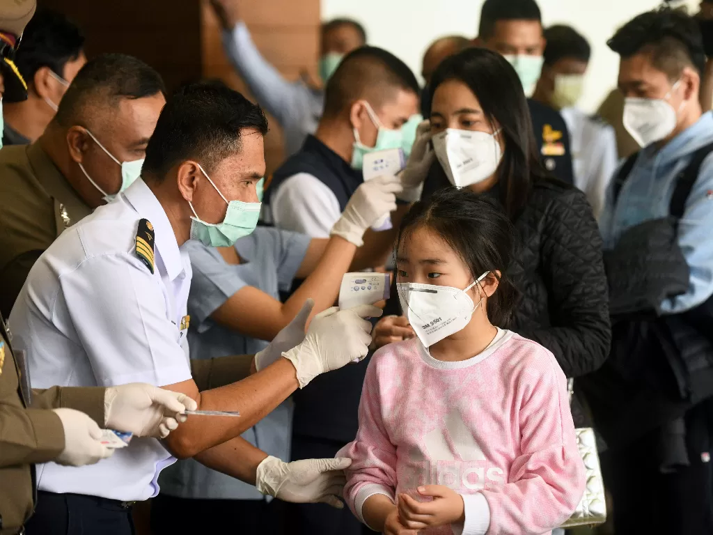 Petugas kesehatan mendeteksi suhu tubuh wisatawan dari virus korona. (REUTERS/Panumas Sanguanwong)