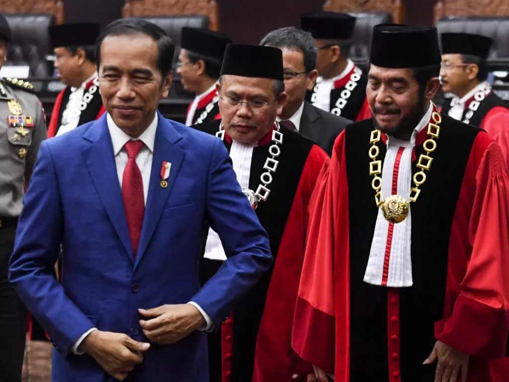 Presiden Joko Widodo (kiri) meninggalkan ruang sidang seusai mengikuti sidang pleno penyampaian laporan tahun 2019 di Gedung MK, Jakarta, Selasa (28/1/2020). (ANTARA FOTO/Hafidz Mubarak A)