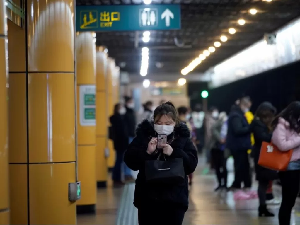 Seorang perempuan menggunakan masker saat menunggu kereta di stasiun subway di Shanghai, Tiongkok, (28/1/2020). (REUTERS/Aly Song)