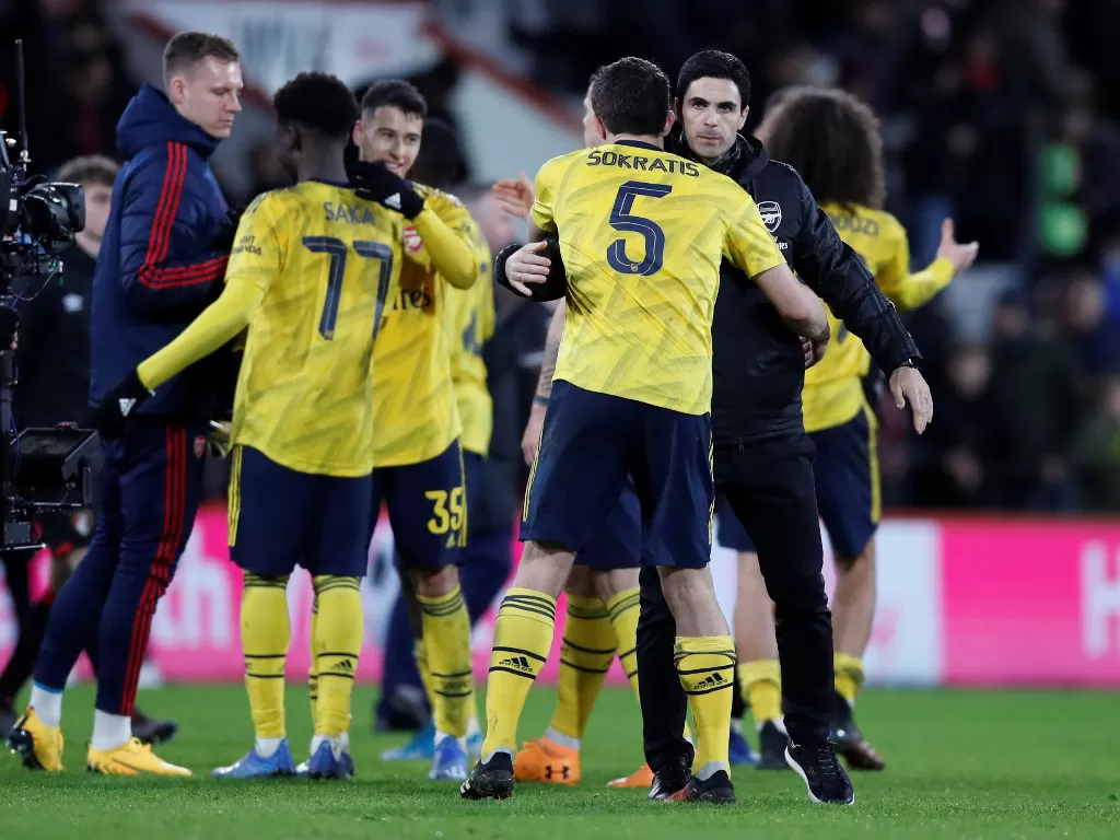Mikel Arteta memeluk para pemainnya usai menang melawan AFC Bournemouth. (REUTERS/David Klein)