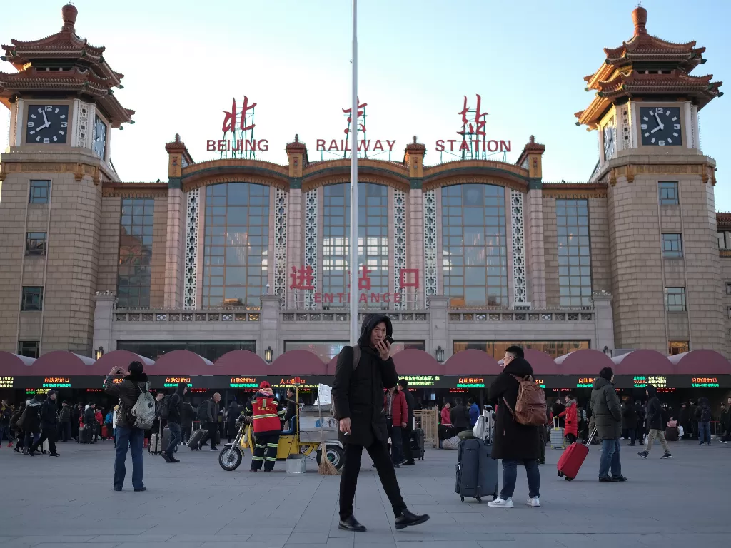 Para penumpang berlalu-lalang di depan Stasiun Kereta Beijing selama musim libur tahun baru Imlek. (REUTERS/Carlos Garcia)