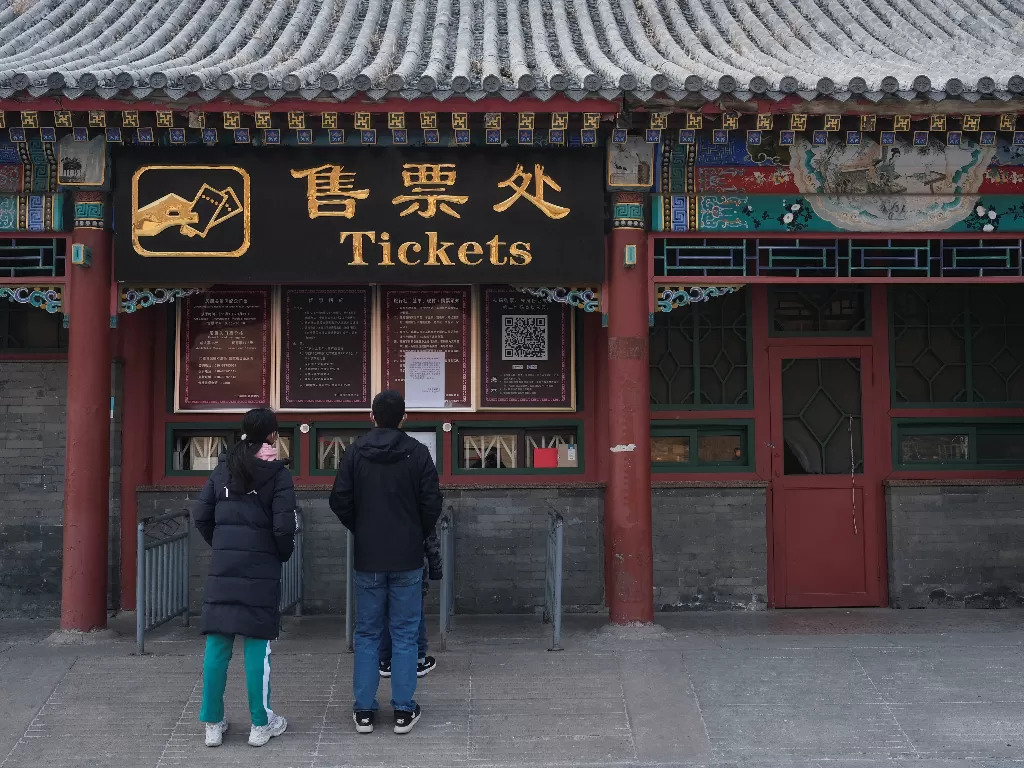 Dua orang wisatawan berdiri di depan konter tiket Tembok Besar Tiongkok sektor Juyongguan yang tutup terkait antisipasi wabah virus korona. (REUTERS/Carlos Garcia Rawlins)