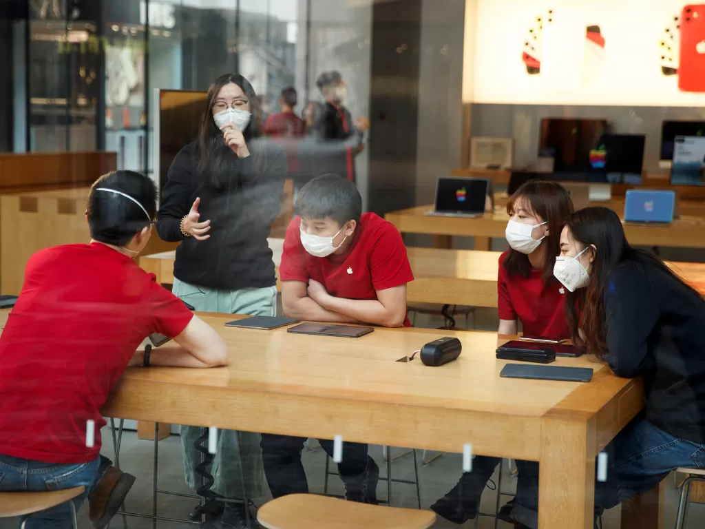 karyawan Apple Store sedang melakukan presentasi dengan menggunakan masker (photo/REUTERS/Thomas Peter)