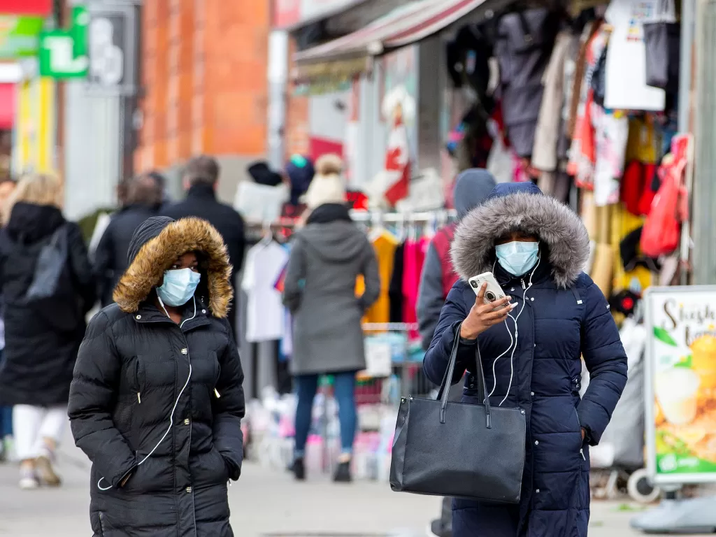 Orang-orang keluar dengan menggunakan masker di distrik Chinatown di pusat kota Toronto, Ontario, setelah 3 pasien dengan virus korona baru dilaporkan di Kanada 28 Januari 2020. (REUTERS /Carlos Osorio)