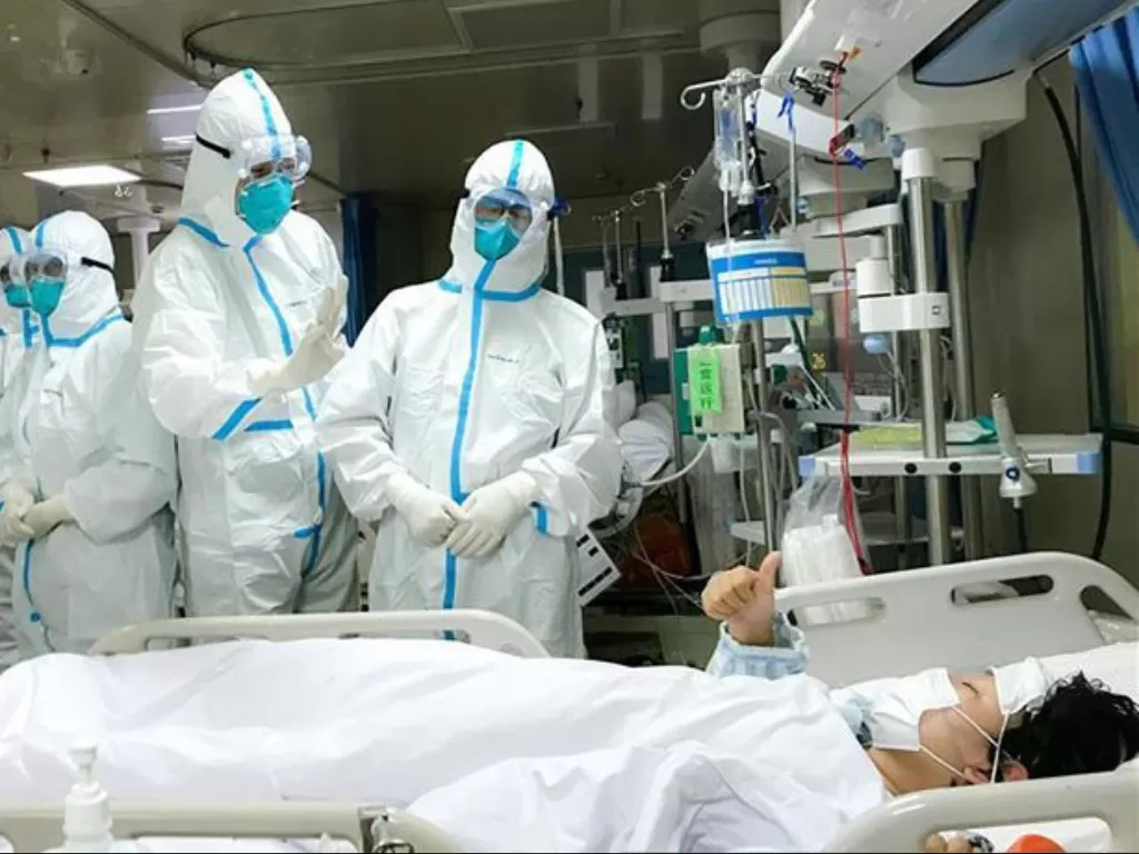 Seorang pasien 2019-nCoV di Rumah Sakit Hankou, Wuhan, memberikan isyarat jempol kepada tim kesehatan dari Second Military Medical University, Senin (27/1/2020). (photo/ANTARA/HO-ChinaNews)