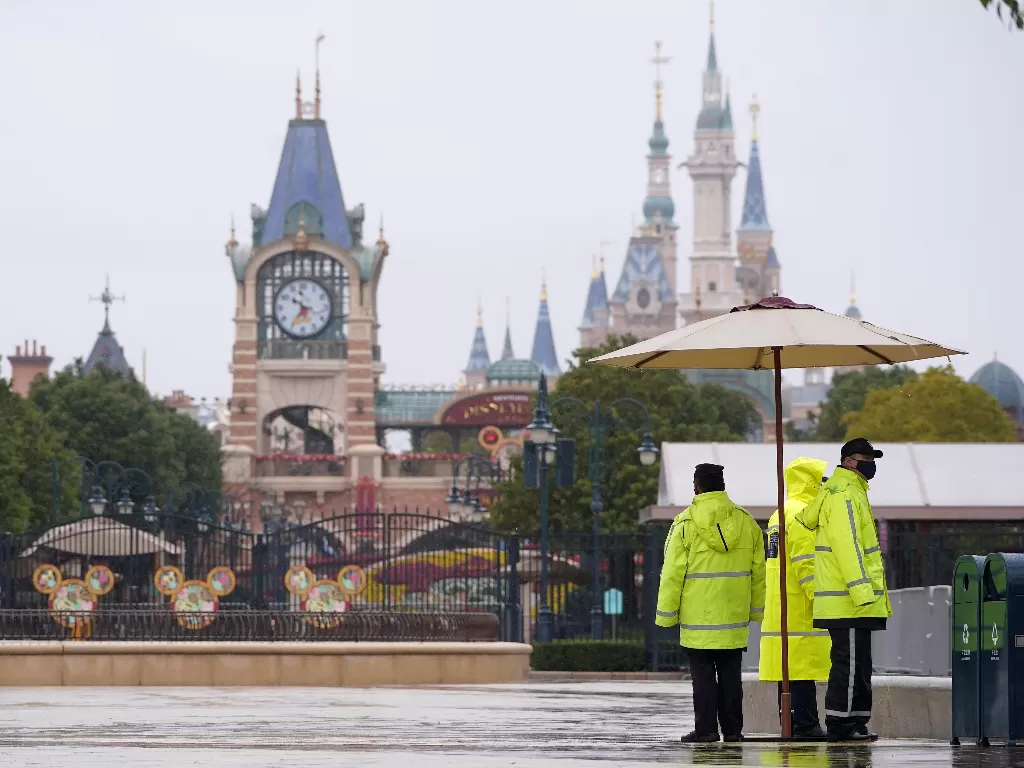 Tiga orang petugas keamanan dengan memakai masker menjaga pintu gerbang Shanghai Disney Resort, Shanghai, Tiongkok, Sabtu (25/1).  (REUTERS/Aly Song)