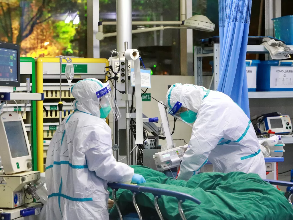 Staf medis dalam pakaian pelindung merawat pasien dengan pneumonia yang disebabkan oleh virus korona baru di Rumah Sakit Zhongnan, Universitas Wuhan, di Wuhan. (photo/REUTERS/China Daily)