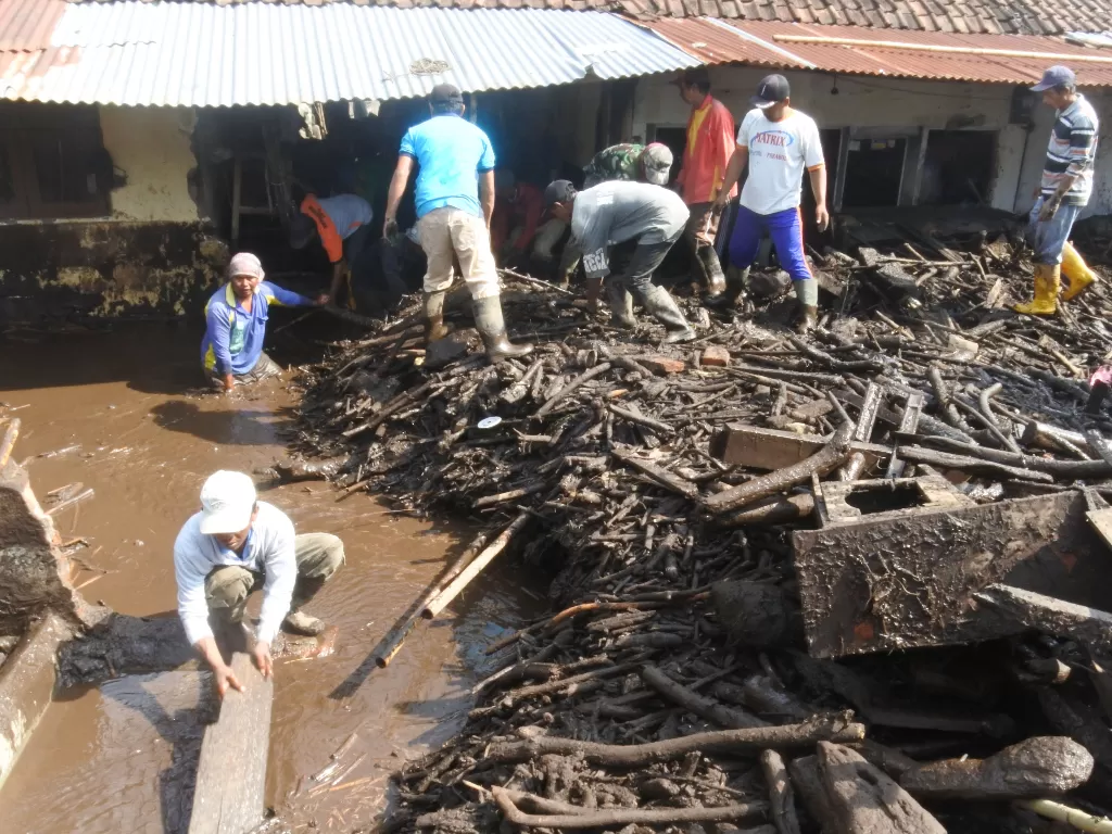 Warga bergotong royong membersihkan sampah pascabanjir bandang di Desa Kalisat, Kecamatan Ijen, Bondowoso, Jawa Timur, Kamis (30/1/2020). (ANTARA FOTO/Seno)
