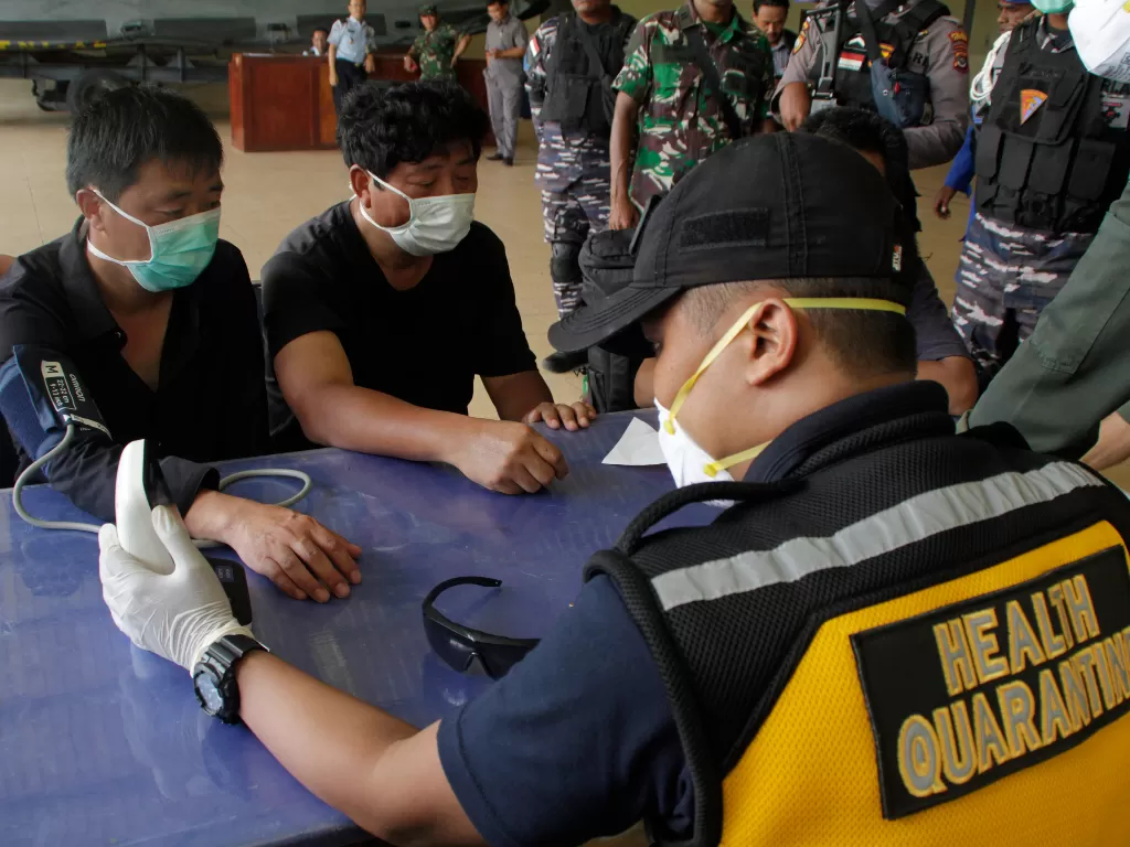 Petugas Karantina Kesehatan Pelabuhan (KKP) Kupang memeriksa kesehatan enam warga negara Tiongkok yang terdampar di perairan Rote Ndao setibanya di Lantamal VII Kupang, NTT, Kamis (30/1/2020). (ANTARA FOTO/Kornelis Kaha)