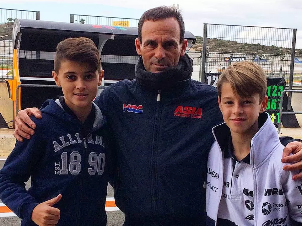 Bos Tim Honda Repsol, Alberto Puig Tengah Berfoto Dengan Dua Anak. (Instagram/@alexescrig_11)
