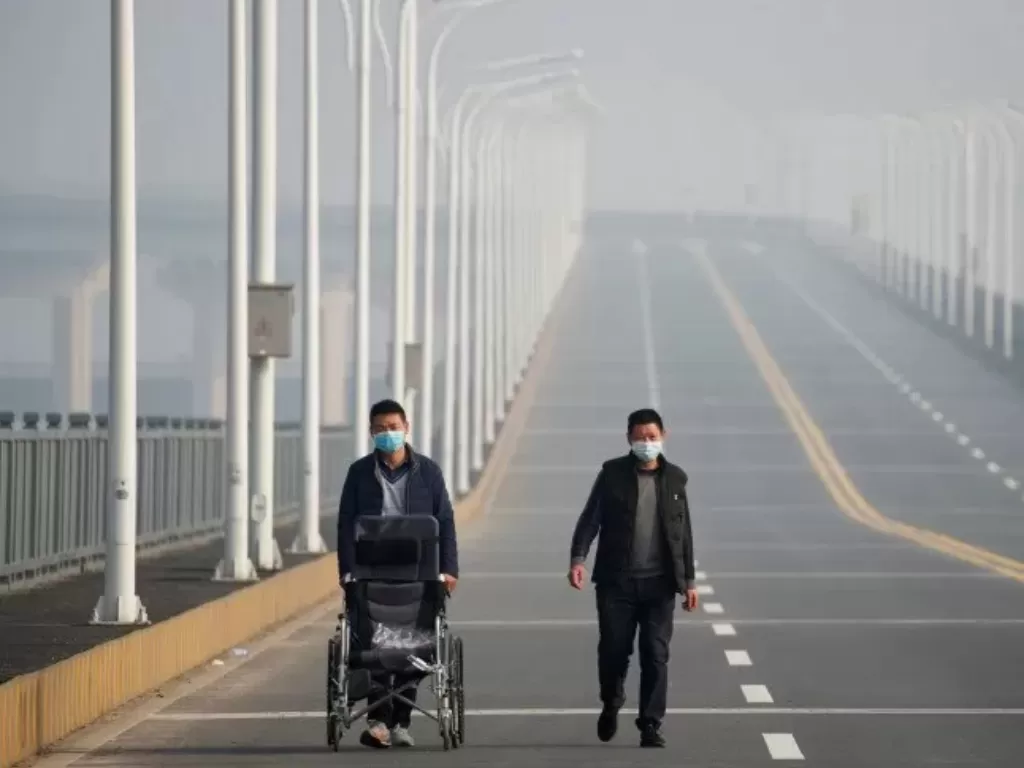 Ilustrasi. Pria yang tiba dari Provinsi Hubei mendekati sebuah pos pemeriksaan di Jembatan Sungai Jiujiang Yangtze di Jiujiang, provinsi Jiangxi, Tiongkok, ketika negara itu dilanda wabah virus corona baru, Jumat (31/1). photo/REUTERS/Thomas Peter