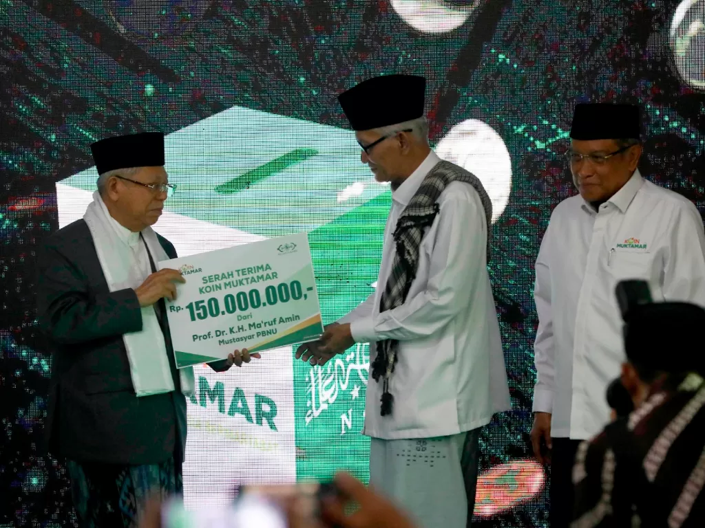 Wakil Presiden Ma'ruf Amin (kiri) menyerahkan sumbangan pada peluncuran Koin Muktamar kepada Rais Aam PBNU Miftachul Akhyar (tengah) disaksikan Ketua Umum PBNU Said Aqil Siradj saat peringatan hari lahir ke-94 Nahdlatul Ulama (NU) di kantor PBNU Jakarta, 