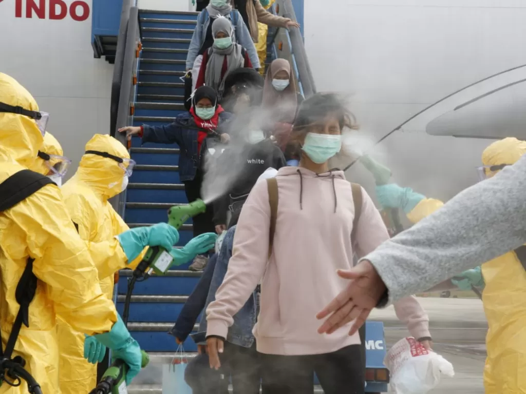 Petugas medis menyemprotkan cairan disinfektan pada WNI dari Wuhan, Tiongkok setibanya di Bandara Hang Nadim, Batam, Kepulauan Riau, Minggu (2/2/2020). (ANTARA FOTO/Kementerian Luar Negeri RI)