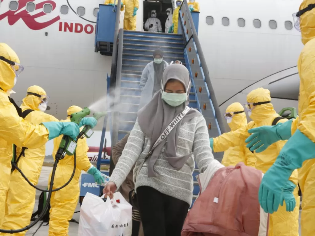 Petugas medis menyemprotkan cairan disinfektan pada Warga Negara Indonesia (WNI) dari Wuhan, China setibanya di Bandara Hang Nadim, Batam, Kepulauan Riau, Minggu (2/2/2020). (Photo/ANTARA/Kementerian Luar Negeri RI)