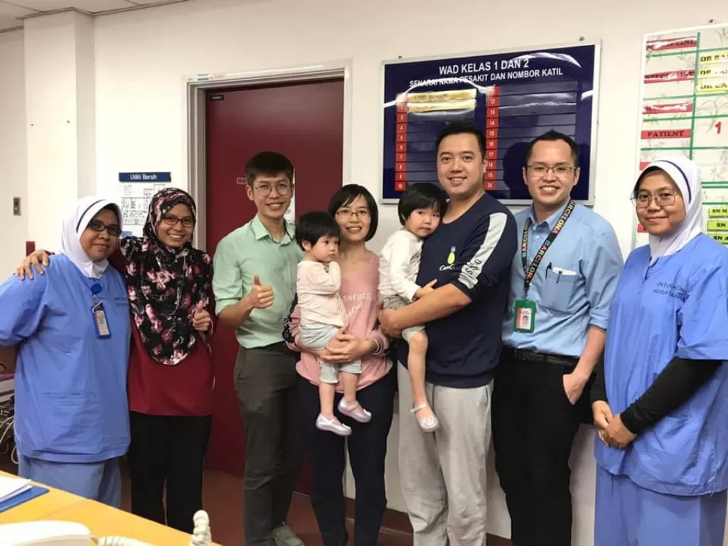 Orang tua anak penderita virus korona berfoto dengan staff medis rumah sakit (Facebook/KEMENTERIAN KESIHATAN MALAYSIA)