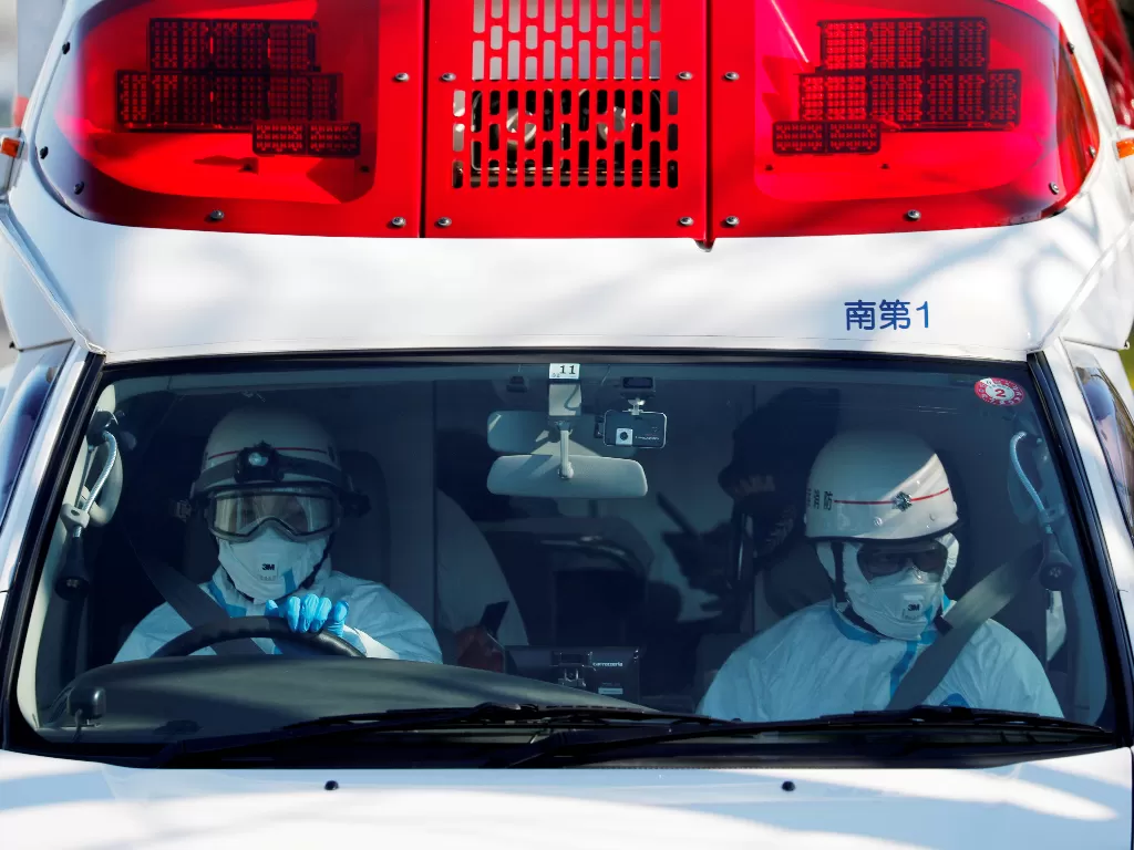 Ilustrasi: Pekerja ambulans dengan gigi pelindung mengendarai ambulans yang diyakini membawa seseorang yang dipindahkan dari kapal pesiar Diamond Princess setelah sepuluh orang dinyatakan positif mengidap virus korona (REUTERS/Kim Kyung Hoon)