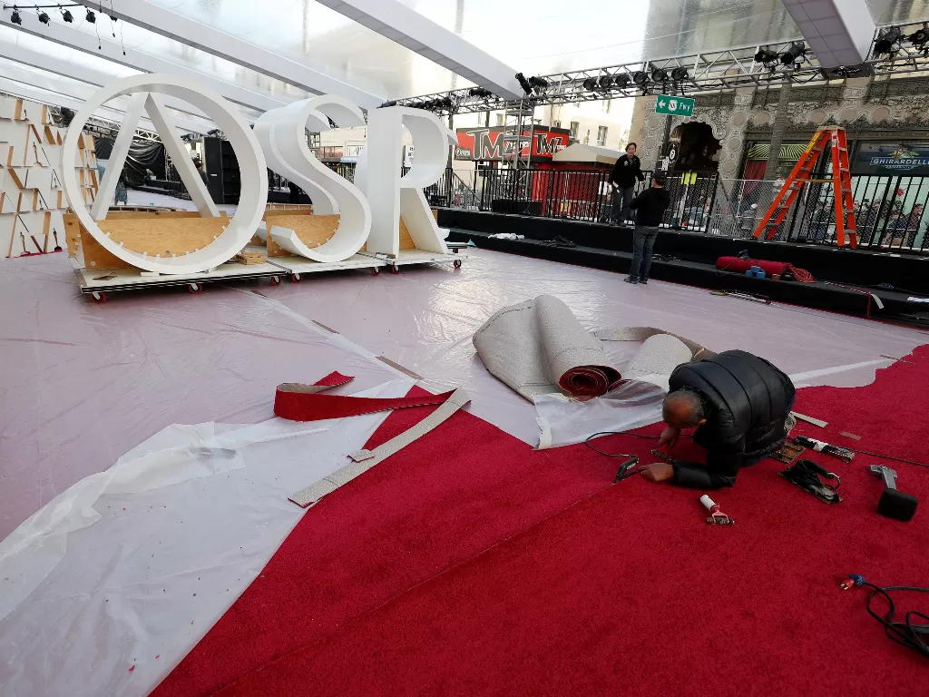  Pekerja menyiapkan area karpet merah dalam persiapan untuk Academy Awards ke-92 di luar Dolby Theatre, Los Angeles, California, AS, Rabu (5/2/2020). (REUTERS/Mario Anzuoni)