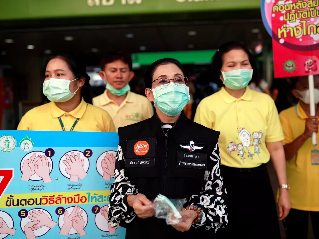 Petugas pemerintahan memberikan masker secara gratis saat tindakan pencegahan penularan virus korona baru di Bangkok, Thailand, Jumat. (Photo/REUTERS/Soe Zeya Tun)