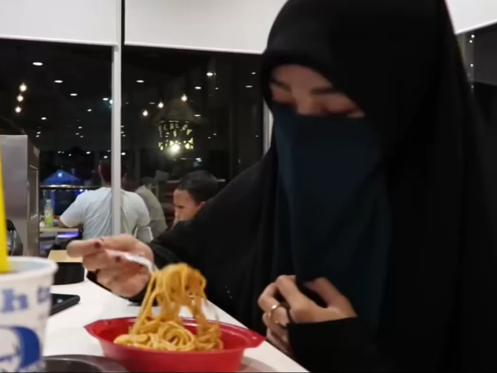 Wanita bercadar makan di tempat umum (Screenshot/YouTube)