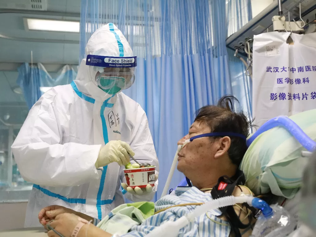 Perawat memberi makan pasien yang terinfeksi virus korona di Rumah Sakit Zhongnan, Universitas Wuhan. (China Daily via REUTERS)