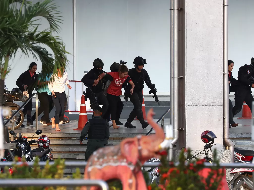 Polisi Thailand saat mengevakuasi warga yang terdampar di dalam pusat perbelanjaan Terminal saat penembakan massal, Minggu (9/2/2020). photo/REUTERS/Athit Perawongmetha